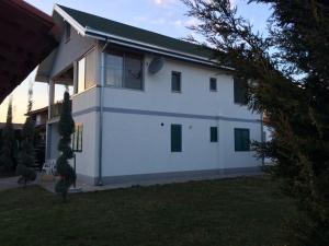 a white house with windows and a yard at Holiday Home Zenit in Ulcinj