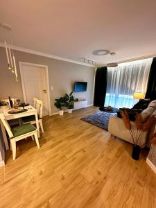 uma sala de estar com uma mesa e um sofá em Apartamenty Kielce- GREEN FOREST APARTAMENT, faktura, parking, centrum em Kielce