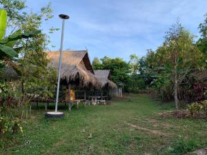 a building with a grass roof and a street light at ลาน​กางเต๊นท์​ข้าวซอย​เขาค้อ​ in Ban Khao Ya Nua