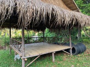 a hut with a thatched roof and a wooden platform at ลาน​กางเต๊นท์​ข้าวซอย​เขาค้อ​ in Ban Khao Ya Nua