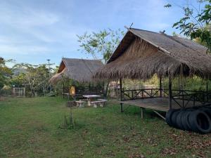 a hut with a bench and a table with a thatched roof at ลาน​กางเต๊นท์​ข้าวซอย​เขาค้อ​ in Ban Khao Ya Nua