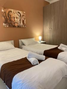 a hotel room with two beds and a painting on the wall at Msida Suites in Msida