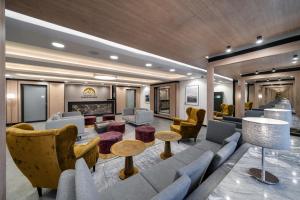a lobby with couches and chairs and a fireplace at RentPlanet - Apartamenty Zakopiańskie in Zakopane