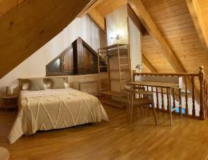 - une chambre mansardée avec un lit et une table dans l'établissement Apartamento A10 de Formigal, 9 personas, amplio y garaje, à Escarrilla