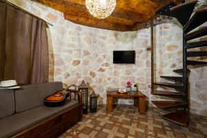 a living room with a staircase and a couch and a table at Zante Hidden Hills in Koiliomenos