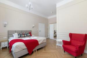 - une chambre avec un lit et une chaise rouge dans l'établissement Rent like home - Lwowska 9, à Varsovie