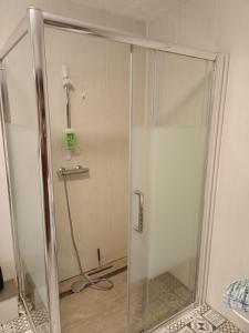 a shower with a glass door in a room at La maison de mamie rdc 