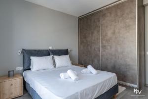 una camera da letto con un letto e asciugamani bianchi di Athens Penthouse with Teracce ad Atene