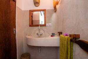 a bathroom with a sink and a mirror at The Wishing Tree in Pingwe +24 photos