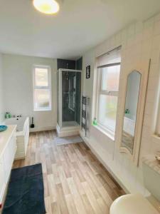 bagno con vasca, lavandino e specchio di 7 Bedroom House in Town Centre near Beach - Sleeps 13 a Hastings