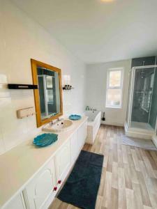 a bathroom with a sink and a mirror and a tub at 7 Bedroom House in Town Centre near Beach - Sleeps 13 in Hastings