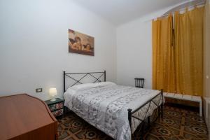 拉斯佩齊亞的住宿－Comfort OneBook - CITRA 011015-LT-2158，一间卧室配有床和黄色窗帘