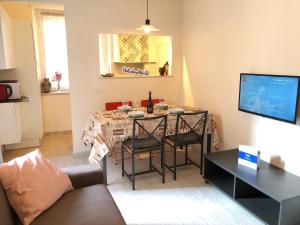 a living room with a table with chairs and a television at L'Angolo Del Borgo by Holiday World in Turin
