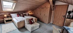 Schlafzimmer im Dachgeschoss mit einem Bett und einem Stuhl in der Unterkunft Urheim Rose in Oy-Mittelberg