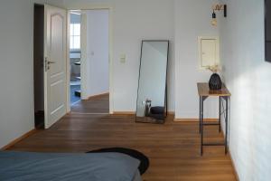 a bedroom with a mirror and a bed and a table at JS-Apartments in Balingen