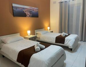 a hotel room with two beds and a painting on the wall at Msida Suites in Msida