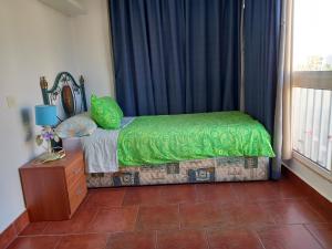a bedroom with a bed with green sheets and a window at Beachfront apartment DIANA 2 in Benalmádena +39 photos