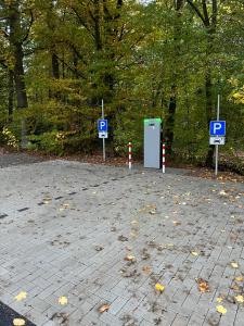 un estacionamiento con dos letreros de estacionamiento y un parquímetro en Twistesee Ferienhaus 42, en Bad Arolsen