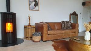 a living room with a couch and a fireplace at Chalet entier 110m2 avec vue et sauna à 10 min des pistes in Sainte-Foy-Tarentaise