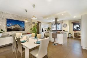 阿德赫的住宿－Villa Rosella Luxes & Pool Private，厨房以及带白色桌椅的用餐室。