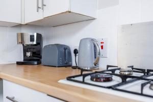 um balcão de cozinha com um fogão e uma torradeira em City Centre - Bright spacious Apartment - Short & Long stays Everhome by Luxiety Stays em Southend-on-Sea