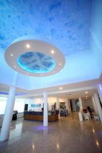a lobby with a blue ceiling with a large aquarium at Anonymous Beach Hotel (Adults 16+) in Ayia Napa +37 photos