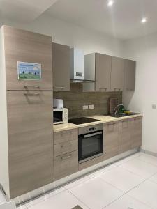 a kitchen with wooden cabinets and a stove top oven at Msida Suites in Msida