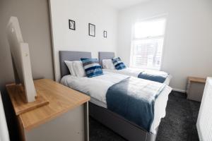 a bedroom with two beds with blue pillows at The Nest In Blackburn in Blackburn