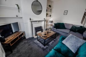 a living room with a couch and a fireplace at The Nest In Blackburn in Blackburn