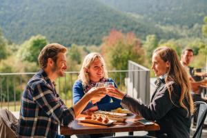 um grupo de pessoas sentadas numa mesa bebendo vinho em MónNatura Pirineus - AJOOO385 em Esterri d'Àneu