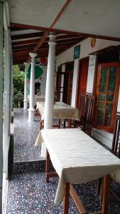 two tables and chairs on the porch of a house at Tree Cool Resort in Ella