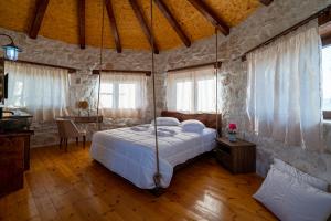 a bedroom with a bed in a room with windows at Zante Hidden Hills in Koiliomenos