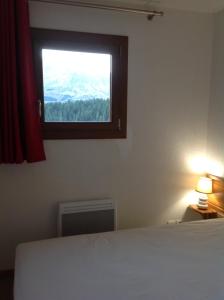 um quarto com uma cama e uma janela em Superb well-equipped apartment em Le Dévoluy