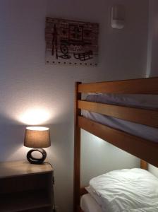 um quarto com uma cama e um candeeiro sobre uma mesa em Superb well-equipped apartment em Le Dévoluy