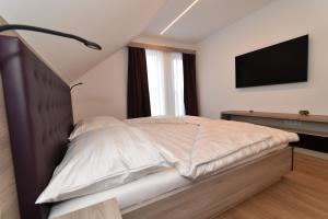 a bedroom with a bed with a television on the wall at Village Loft in Sankt Stefan im Rosental