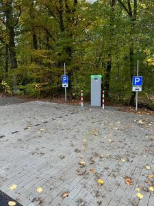 a parking lot with two parking signs and a parking meter at Twistesee Ferienhaus 2 in Bad Arolsen