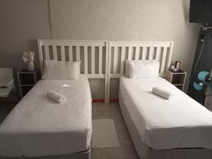 2 łóżka w pokoju z białą pościelą i poduszkami w obiekcie BARAKA mtata ! w mieście Mthatha