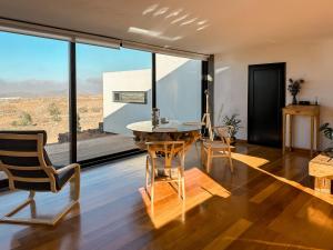 um quarto com uma mesa e cadeiras e uma grande janela em CASA LA BOCAINA - private villa with panorama & ocean view em Villaverde