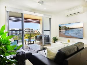 sala de estar con sofá y ventana grande en Emerald lakes 3 level villa en Gold Coast