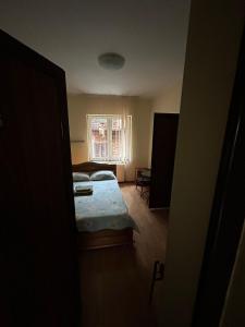 Habitación pequeña con cama y ventana en Casa Rosa en Băile Olăneşti