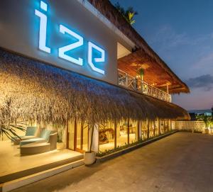 a resort building with a thatched roof at IZE Canggu by LifestyleRetreats in Canggu