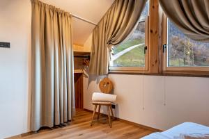 um quarto com uma cadeira em frente a uma janela em Rotwandterhof Wohnung Nest em Barbiano