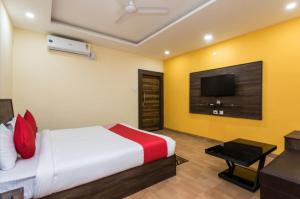 a hotel room with a bed and a flat screen tv at Fun and Food Resort & Holidays in Harsola