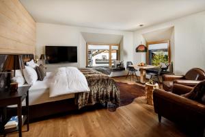 Chalet Piz Buin في كلوسترز: غرفة نوم بسرير كبير وغرفة معيشة