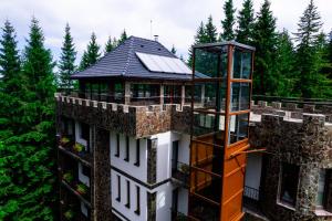 um edifício com uma torre em cima dele em Castelul de Piatra em Păltiniş