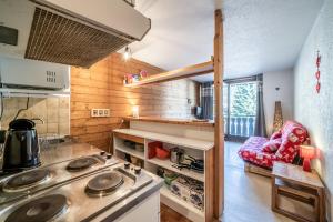 a kitchen with a stove top oven in a room at Studio Chatel - Au pieds du Linga in Châtel