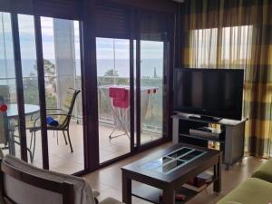 uma sala de estar com uma televisão e uma varanda em Vila Oropesa Vii Nº 1149 em Oropesa del Mar
