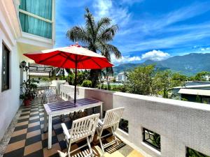 a patio with a table and chairs and an umbrella at White Palace B&B in Ji'an