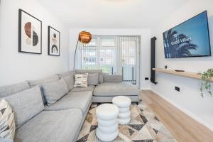 a living room with a couch and a tv at The Ivyhouse Lodge in Dagenham