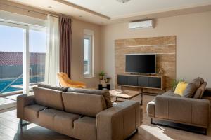 un soggiorno con 2 divani e una TV a schermo piatto di Villa Antares a Duće